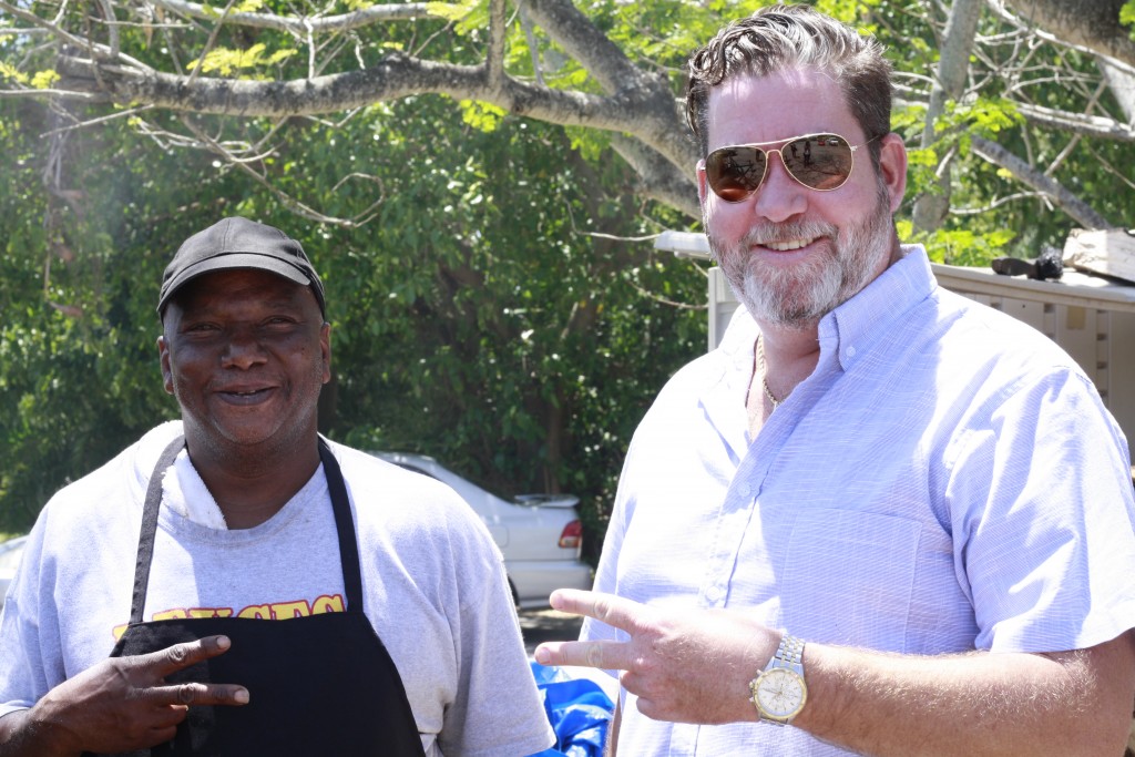 Patrick Collins, neighbor to the gallery and owner of Deuces BBQ, poses with one of his cooks smoking ribs and shrimp during the peak of lunch hour.