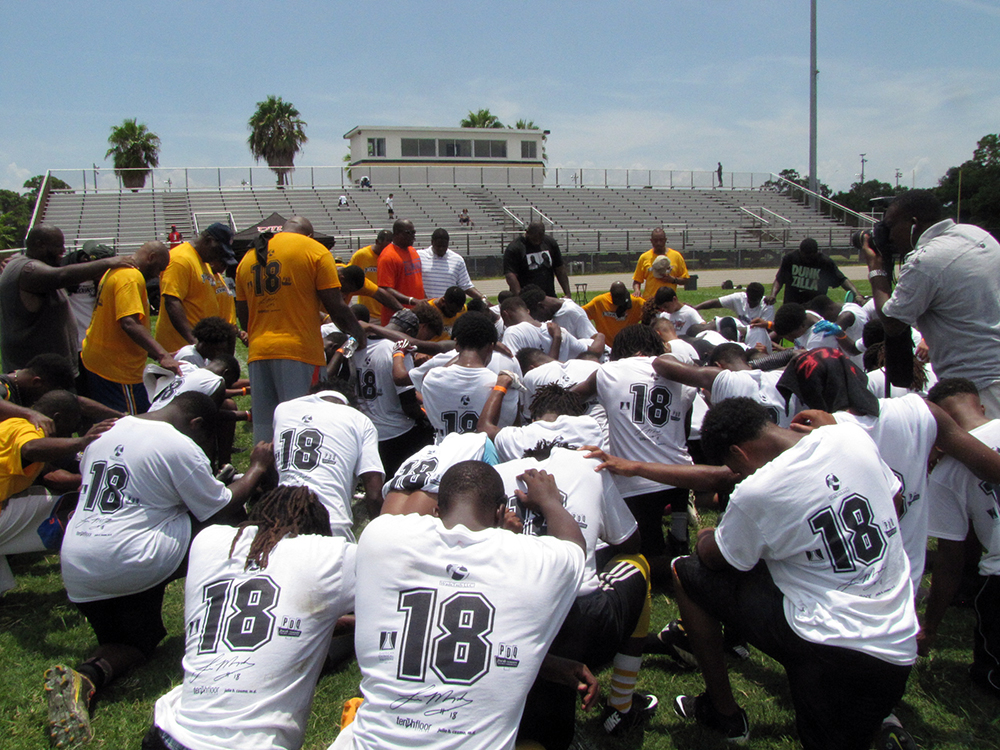 Murphy’s father, the Rev. Louis M. Murphy Sr. (in orange shirt), leads some of the high school campers in prayer.