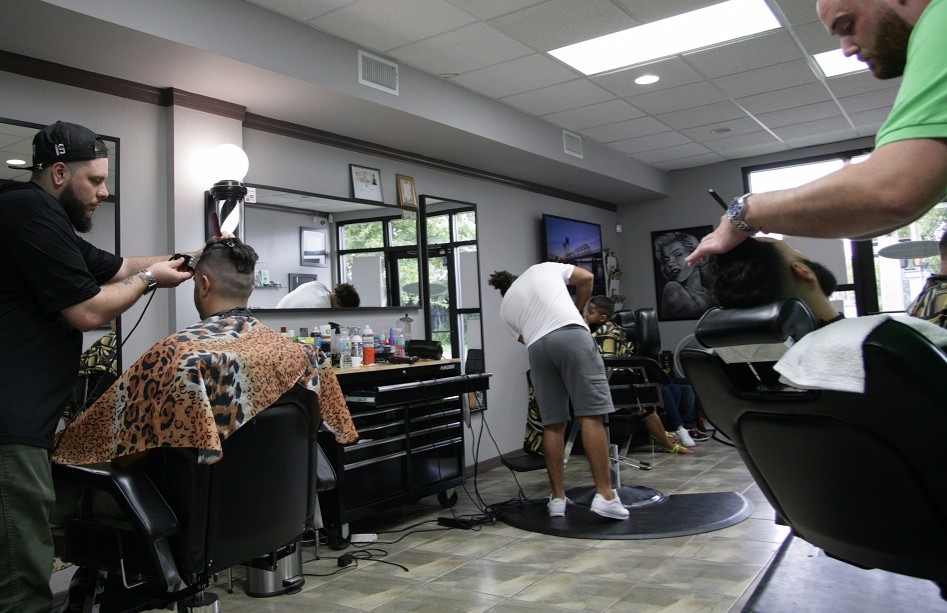 Barbers Shawn Oliveras, Derek Fraley, and Kevin Rix cutting hair at Chago's Barber shop. Photo by Eric Vaughan.